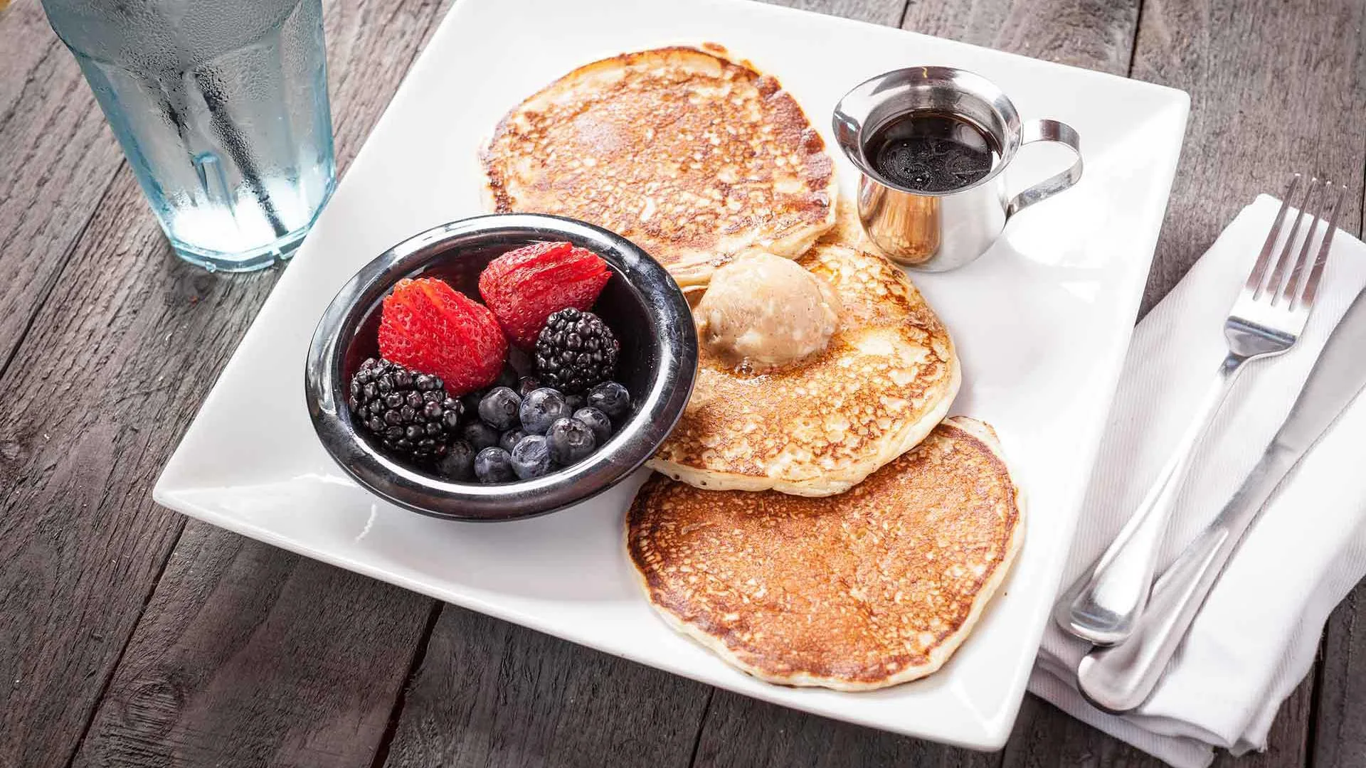 Moviehouse & Eatery pancakes with berries and syrup served on a plate